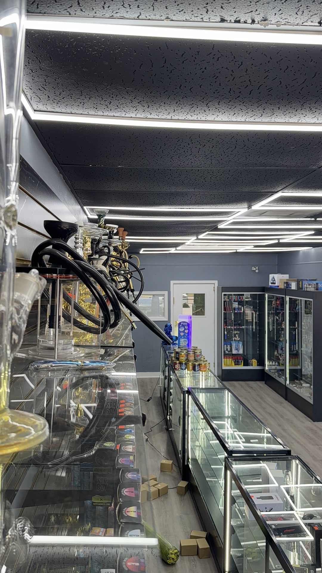 High Mood Smoke Shop interior featuring premium glass display cases and luxury hookah collection